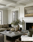 living room with a fireplace, a painting, sofa, coffee table, and decorative items.
