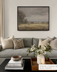 living room with gray sofa, decorative pillows, and a framed landscape painting on the wall.