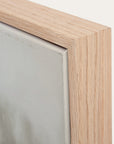 close-up of a wooden picture frame corner with a neutral background.