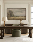 modern office interior with a wooden desk, green chair, and framed landscape painting on the wall.