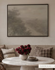 a closer view of forgotten road in a black floater frame above a linen banquette with plaid and patterned pillows, a round marble table, a vase of deep red flowers, and stacked stone bowls. shown in floater black, 48 x 36.