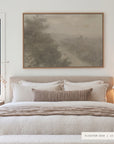 forgotten road in a light oak floater frame above an upholstered bed with white linen bedding, a striped lumbar pillow, a knit throw, and a pleated lamp on the nightstand. shown in floater oak, 60 x 40.