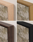 four square close-up views of picture frames in different finishes: light natural wood, medium warm wood, dark brown wood, and matte black, each shown with floral-patterned artwork against a light wall.