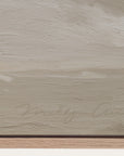 textured beige surface with a signature at the bottom right corner
