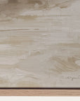 textured beige surface with a signature at the bottom right corner