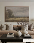 living room with beige sofa, decorative vases, and a landscape painting on the wall.