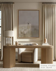 modern home office with wooden desk, chair, and framed artwork on the wall.