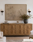 A large framed wall art print with a muted abstract tree design in warm beige and brown tones, displayed above a wooden credenza in a styled living room setting. __lifestyleImage