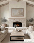 living room with stone fireplace, beige sofas, and a coffee table.