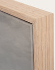 close-up of a wooden frame corner with a gray background.