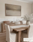 dining room with wooden table, chairs, and a framed artwork on the wall.