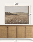 wicker sideboard with framed landscape art above it on a white background