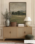 wooden sideboard with decorative items against a wall with a landscape painting. __lifestyleimage