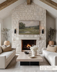 living room with stone fireplace, white sofas, and a painting above the fireplace.