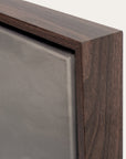 close-up of a wooden frame corner with a metallic surface.