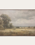 framed landscape painting of a field with sheep and trees on a white wall.