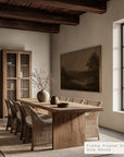 dining room with wooden table and chairs, framed artwork on the wall.