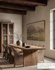 dining room with wooden table and chairs, framed artwork on the wall.