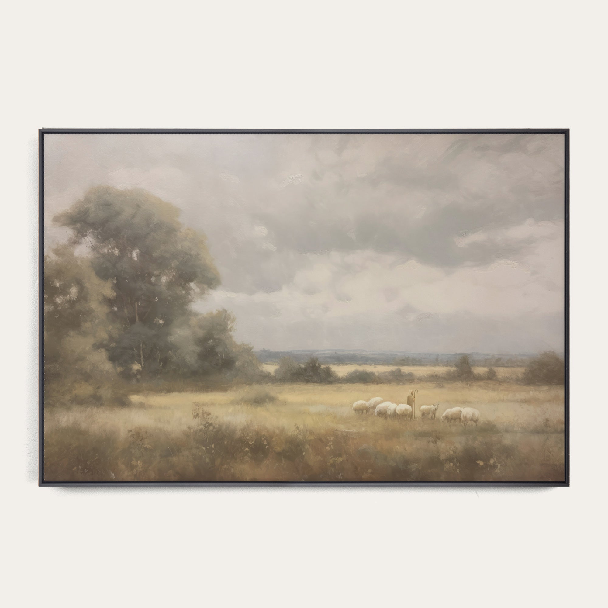 Framed landscape painting of a field with sheep and trees on a white wall. 