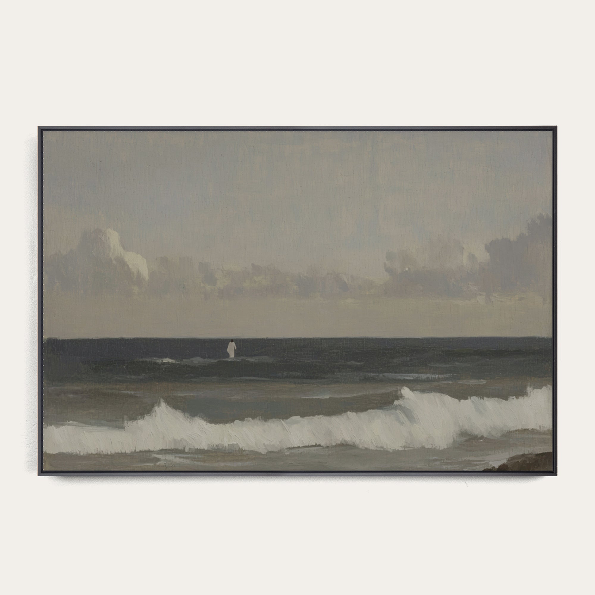 Framed artwork of a coastal scene with waves and a distant figure on a beach. 