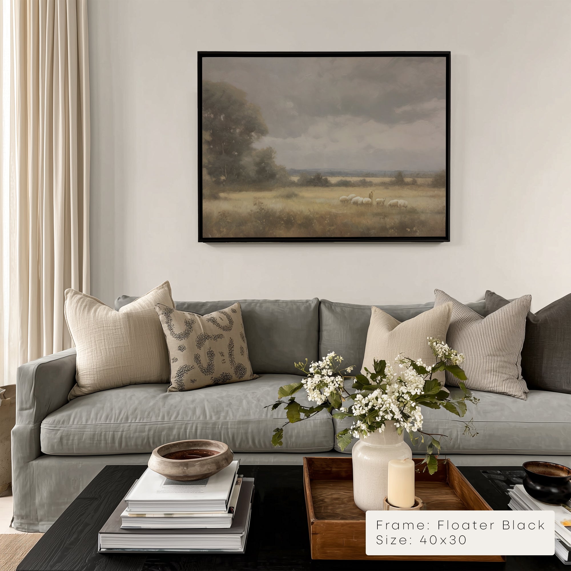 Living room with gray sofa, decorative pillows, and a framed landscape painting on the wall.