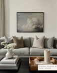 modern living room with a gray sofa, decorative pillows, and a framed artwork on the wall.