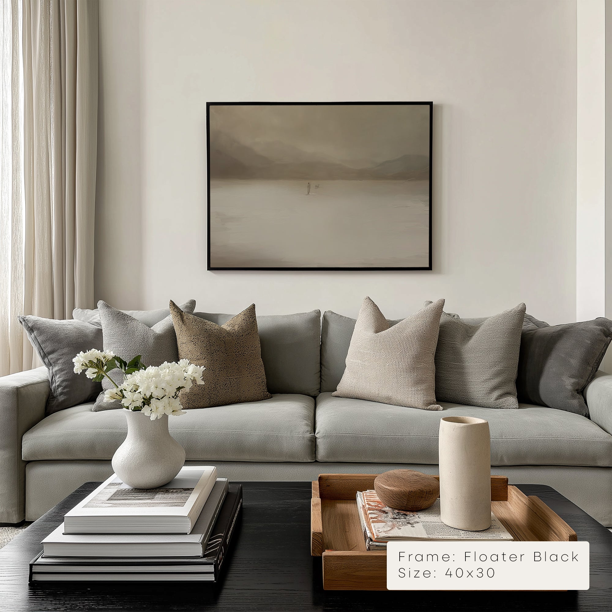 Modern living room with a gray sofa, decorative pillows, and a framed artwork on the wall.