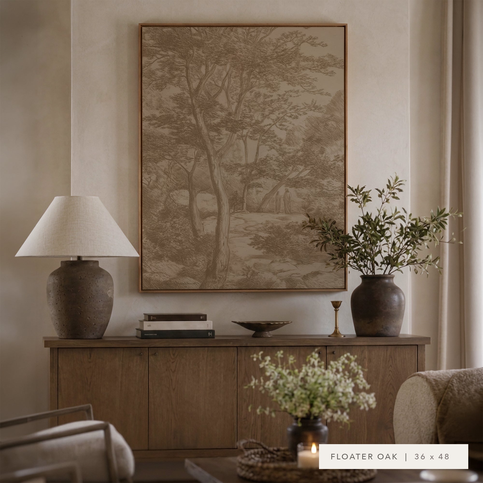 A large framed wall art print featuring a sepia-toned forest landscape hangs above a wooden console table in a styled living room. The print is labeled 'FLOATER OAK | 36 x 48' in the bottom right corner. __lifestyleImage