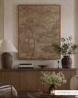 A large framed wall art print featuring a sepia-toned forest landscape hangs above a wooden console table in a styled living room. The print is labeled 'FLOATER OAK | 36 x 48' in the bottom right corner. __lifestyleImage