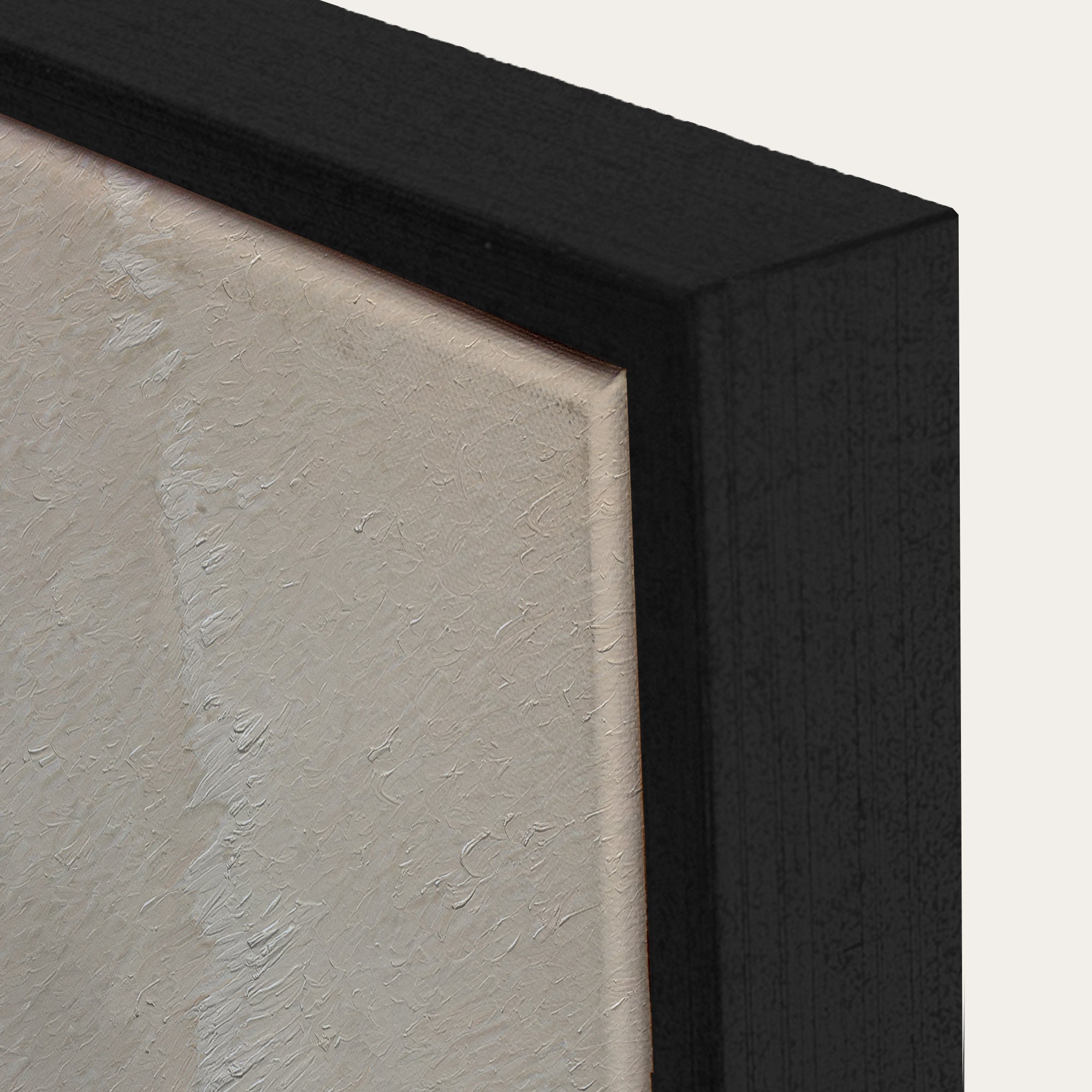 Close-up of a black framed artwork with a textured beige background 