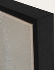 close-up of a black framed artwork with a textured beige background 
