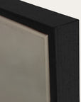 close-up of a black rectangular object with a textured surface on a light gray background 
