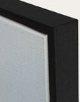 close-up of a black frame corner with a textured white surface. 