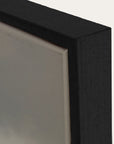 close-up of a black rectangular object with a reflective surface on a white background 