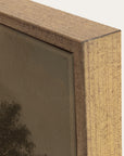 close-up of a wooden picture frame corner with a blurred artwork inside. 