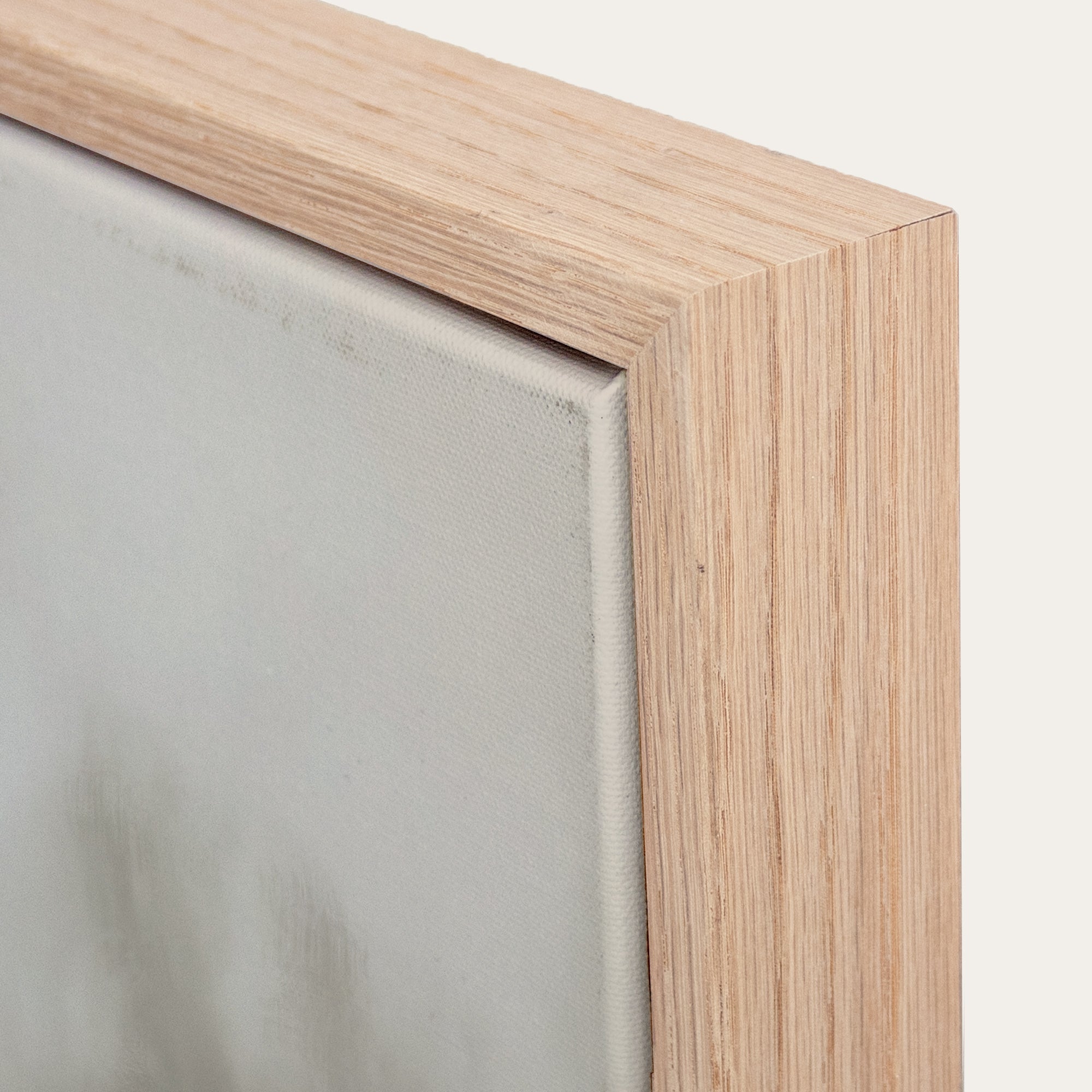 Close-up of a wooden picture frame corner with a neutral background. 