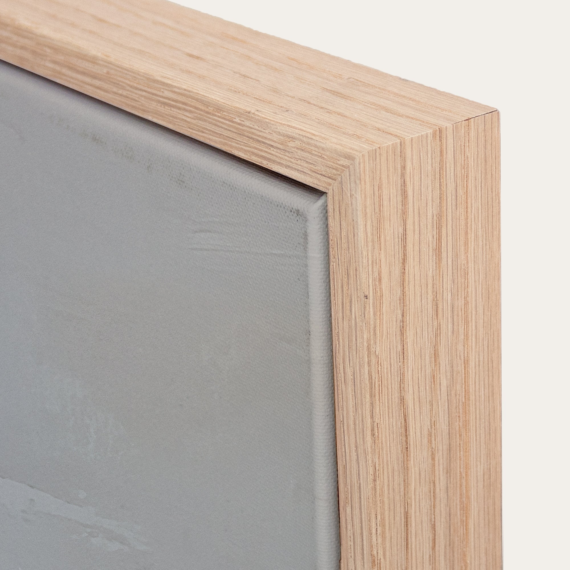Close-up of a wooden frame corner with a gray background 
