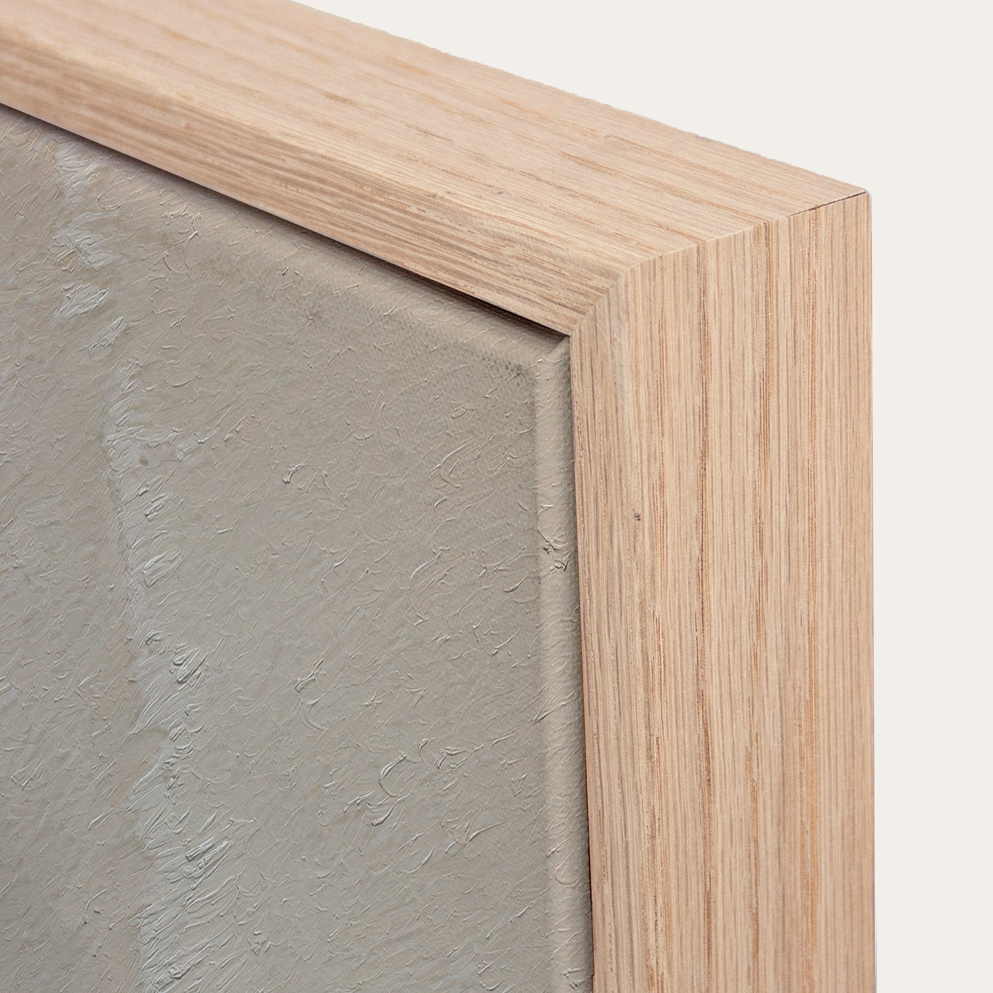 Close-up of a wooden frame corner with a textured gray surface inside 