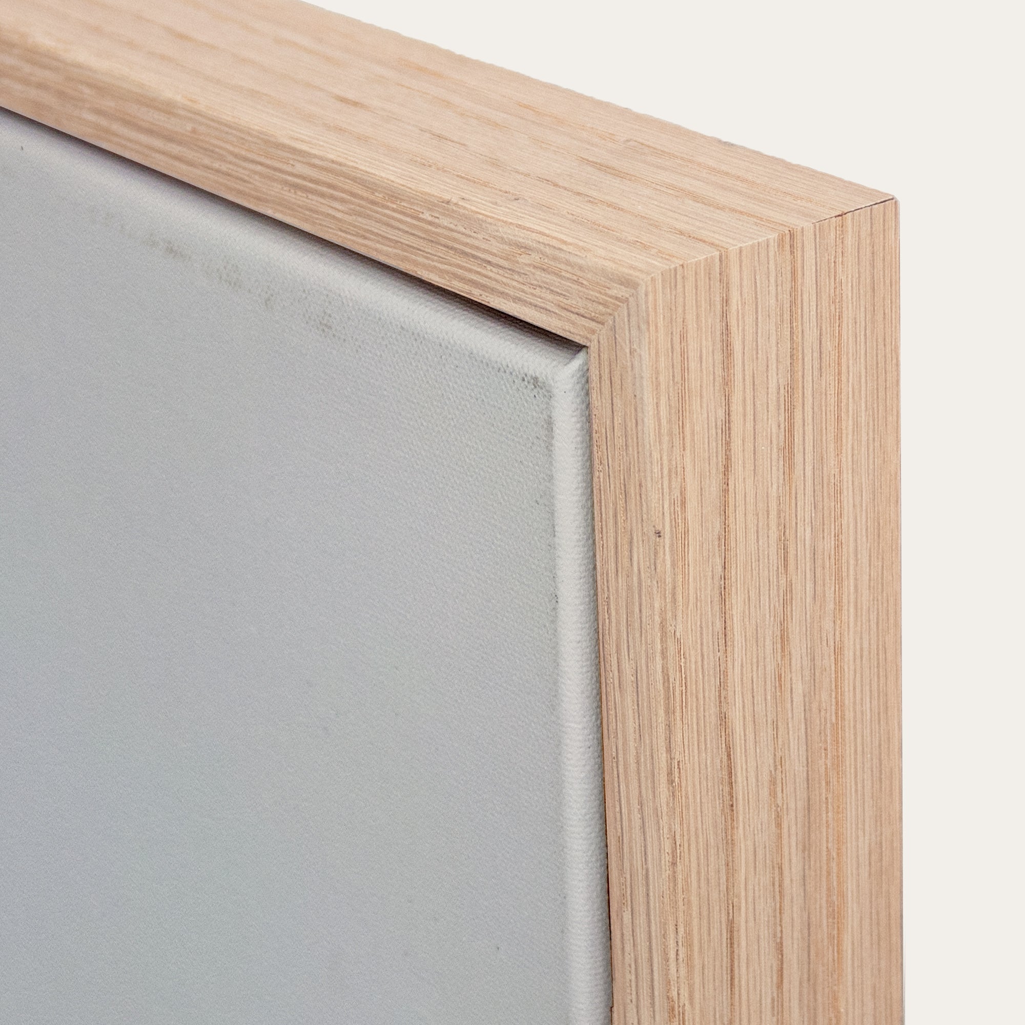 Close-up of a wooden picture frame corner with a neutral background 