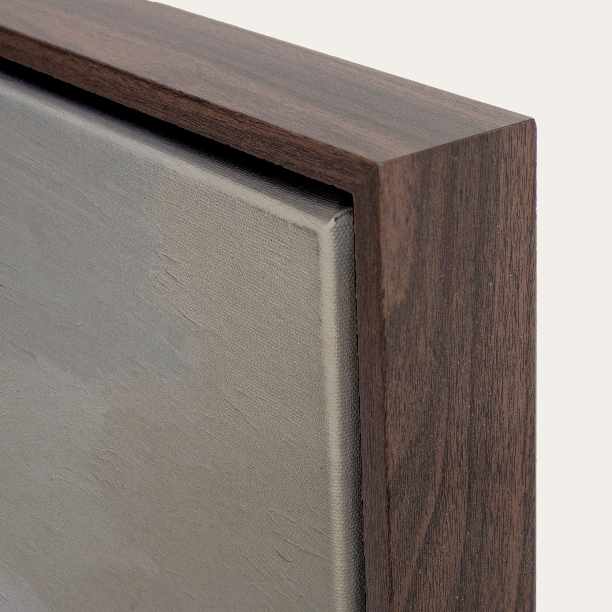 Close-up of a wooden picture frame corner with a neutral background 