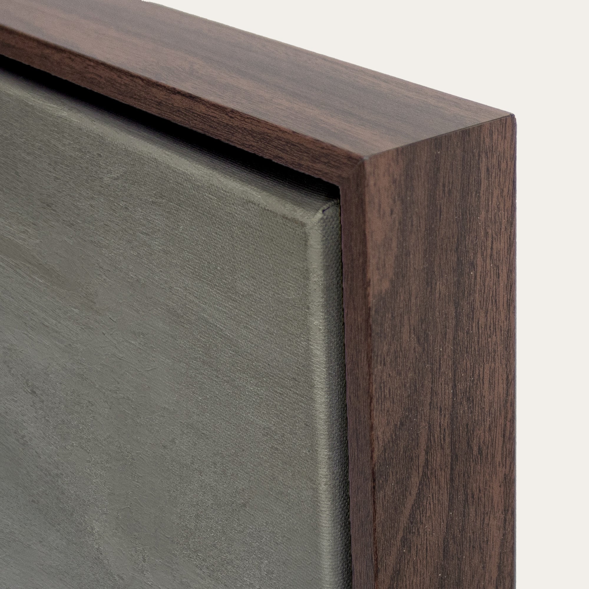 Close-up of a wooden frame corner with a gray background 