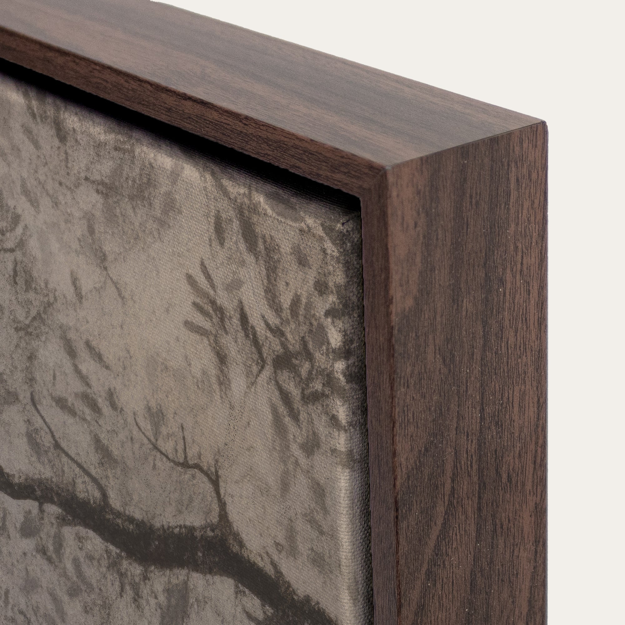 Close-up of a wooden frame with a textured wall art piece inside 