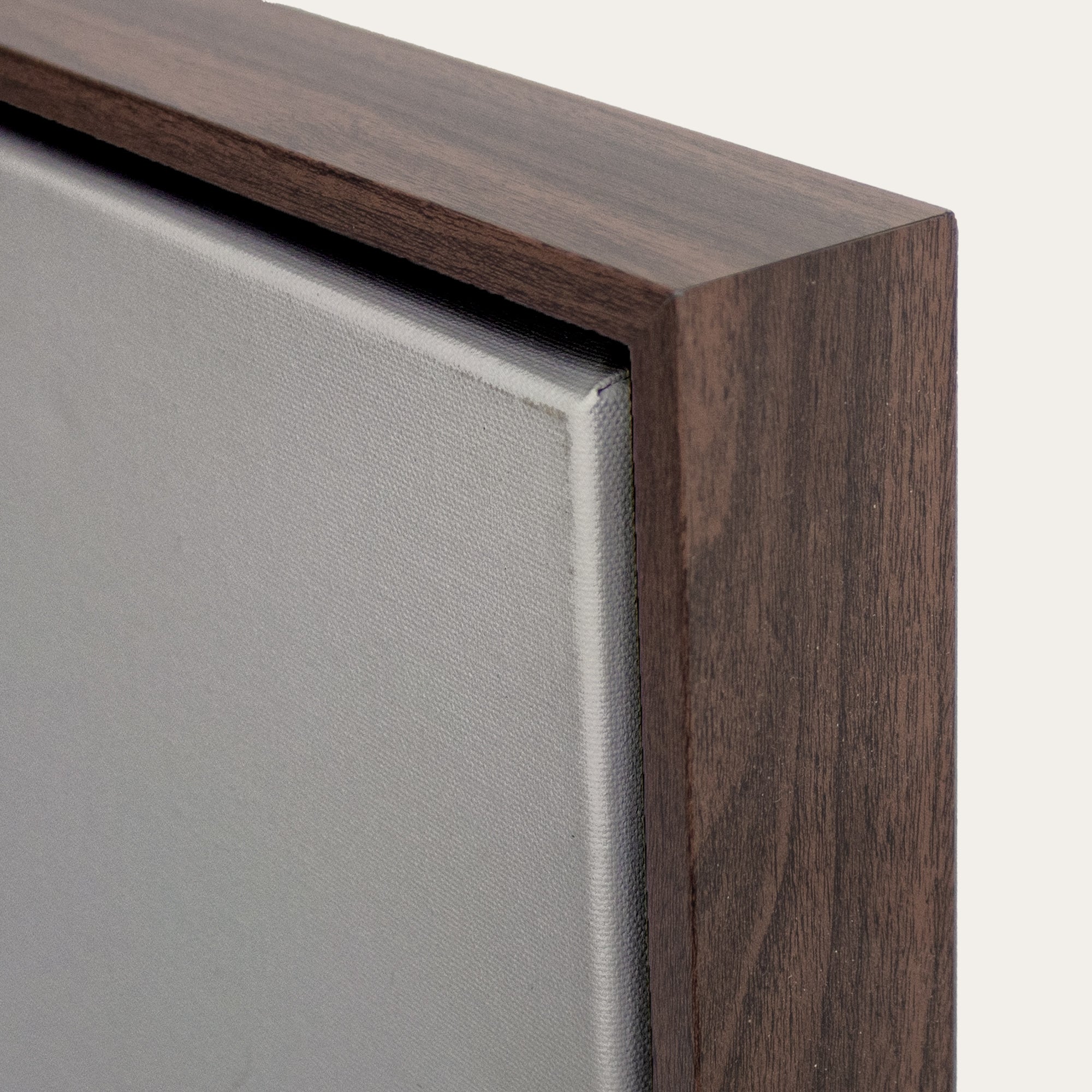 Close-up of a wooden picture frame corner with a neutral background 