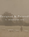 sheep grazing in a field with a blurred background and 'designed & painted by madelynn ave' text overlay.