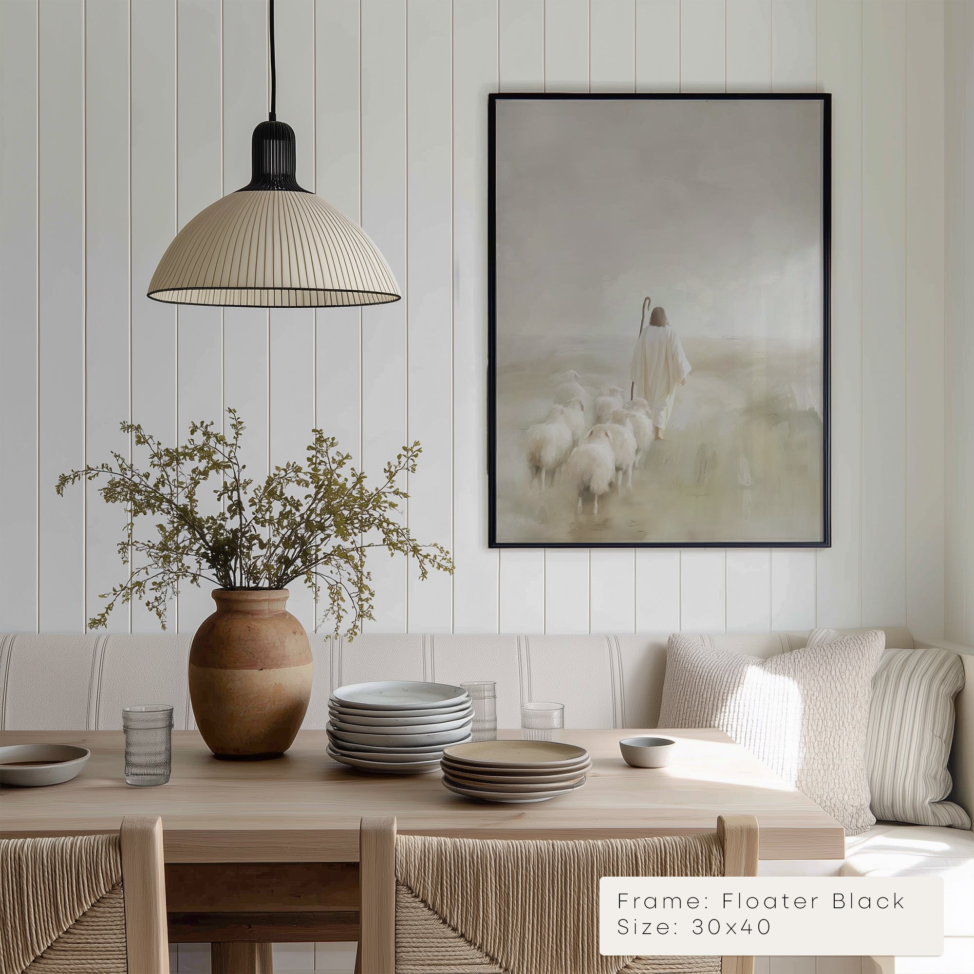 Dining room with wooden table, vase with plants, and framed artwork on the wall.