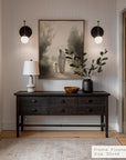 foyer with wooden console table, lamp, and framed artwork on a neutral wall. __lifestyleimage
