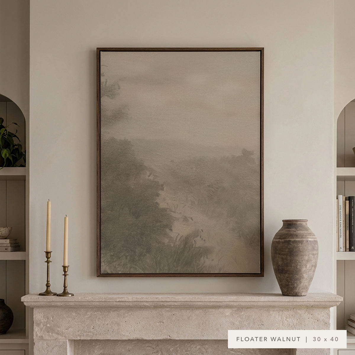 Forgotten Road in a dark walnut floater frame above a cream stone mantel with brass candlesticks and a rustic clay vase, between arched built-in shelves. Shown in Floater Walnut, 30 x 40. __lifestyleImage
