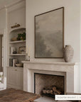 a wider view of forgotten road in a dark walnut floater frame above a cream stone fireplace with a herringbone firebox and stacked logs, beside built-in shelves and a rustic wooden coffee table. shown in floater walnut, 30 x 40.