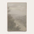 Forgotten Road vertical art print in a light oak floater frame. A foggy road fades past a dark stand of trees in soft grays and warm stone tones, shown against a plain off-white wall. #Oak