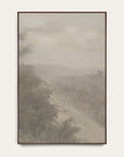forgotten road vertical art print in a dark walnut floater frame. a foggy road fades past a dark stand of trees in soft grays and warm stone tones, shown against a plain off-white wall. 